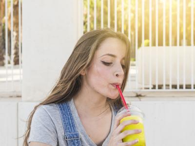 Bicikliző lány jégkását iszik szívószállal